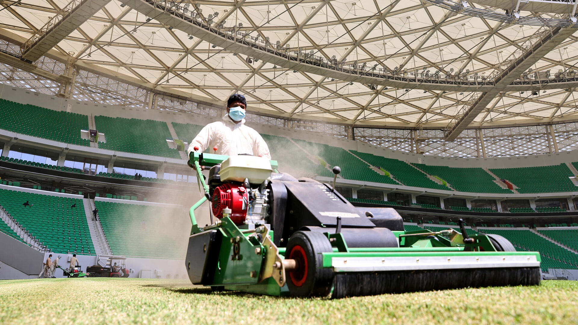 פועל זר מכסח את הדשא באצטדיון ב דוחא