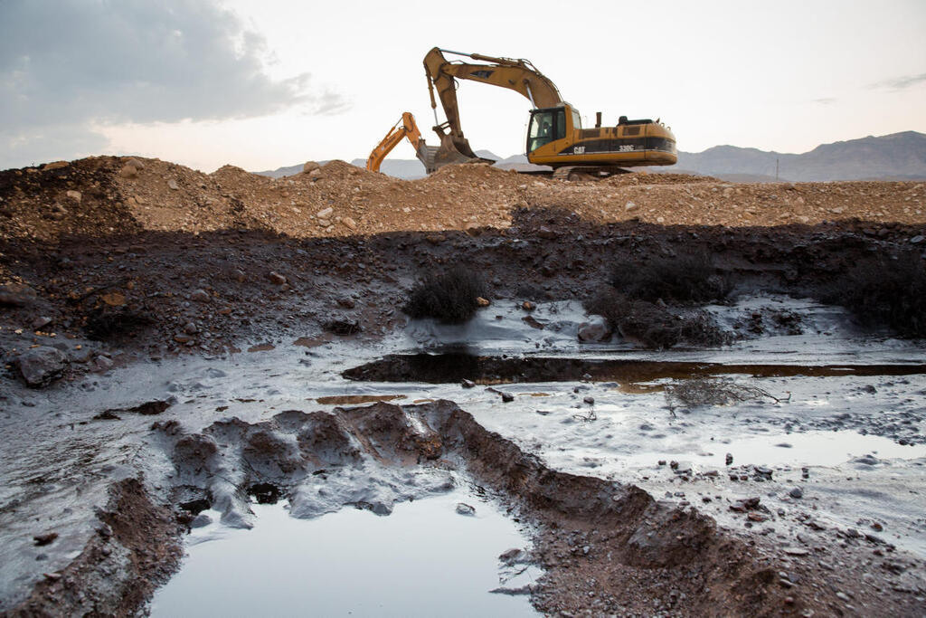 טרקטור מפנה את ה קרקע ה ספוגה ב נפט אסון נפט שמורת עברונה ב־ 2014