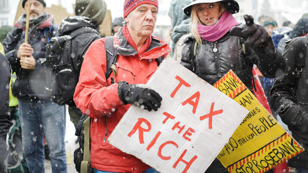 מפגינים בדאבוס קוראים להטיל מס על עשירים