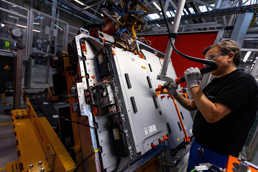 כלכליסט עובד במפעל להרכבת סוללות חשמליות של מרצדס בנץ בגרמניה