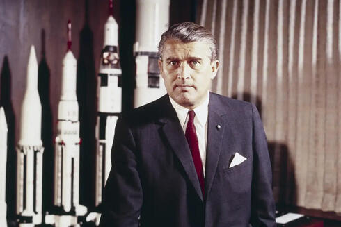 ורנר פון בראון במשרדו בנאס"א, מאחוריו שורת הטילים שתכנן, צילום:  NASA