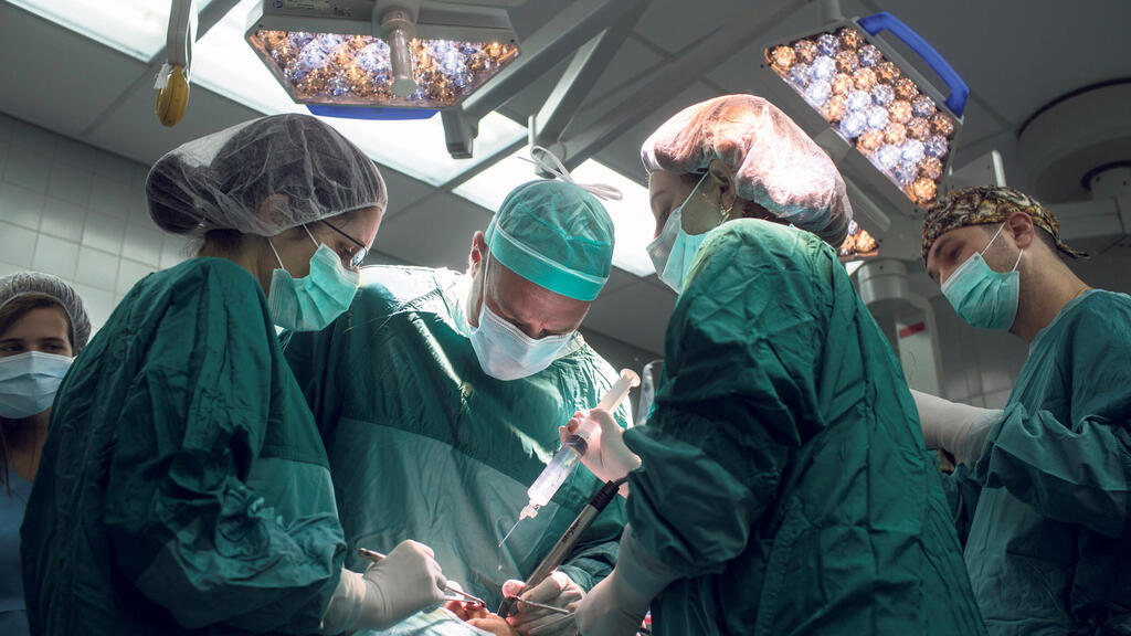 רופאים מנתחים (צילום: תומי הרפז) רופאים מנתחים בחדר ניתוח