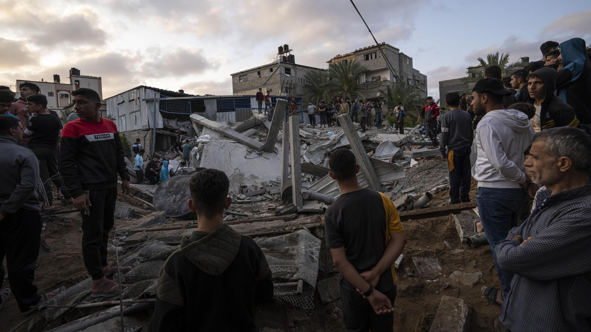 פלסטינים עומדים על הריסות ביתו של זיאד סלמי ב רצועת עזה 13.5.23
