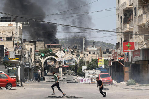 נערים פלסטינים בורחים מהפצצות צה"ל בג