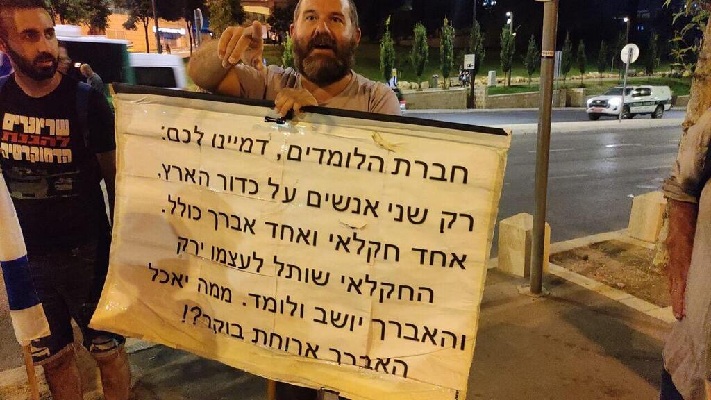 בנו של חבר הכנסת לשעבר מנחם אליעזר מוזס מאגודת ישראל  אוחז בשלט הזה בגן סאקר