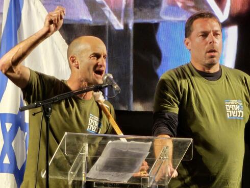 אייל נווה ורון שרף מארגון "אחים לנשק" קוראים לעצור את החקיקה מעל הבמה בירושלים. "לא נשרת תחת דיקטטורה", צילום: עמיר קורץ
