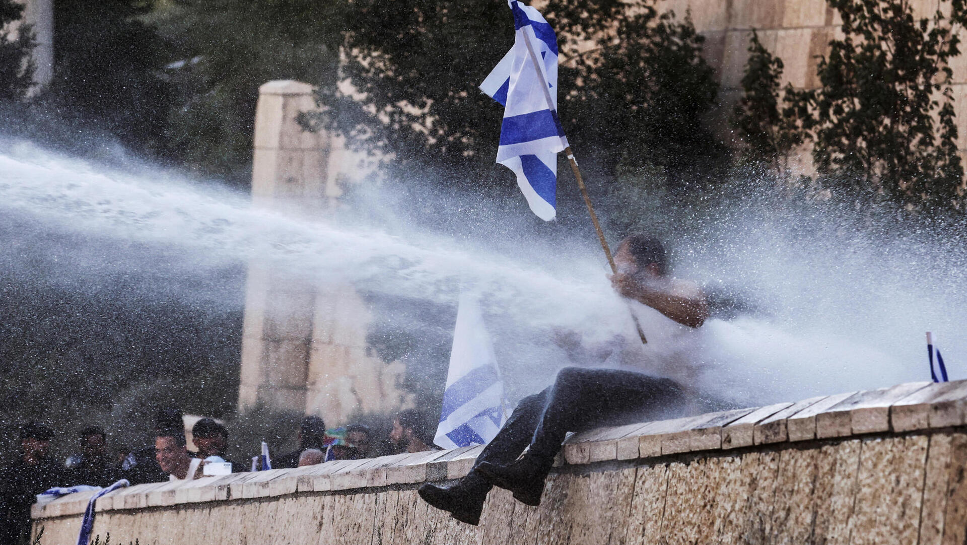 המשטרה משתמשת מכתזית בתותח מים על מפגינים בהפגנה המהפכה המשפטית הפיכה משטרית