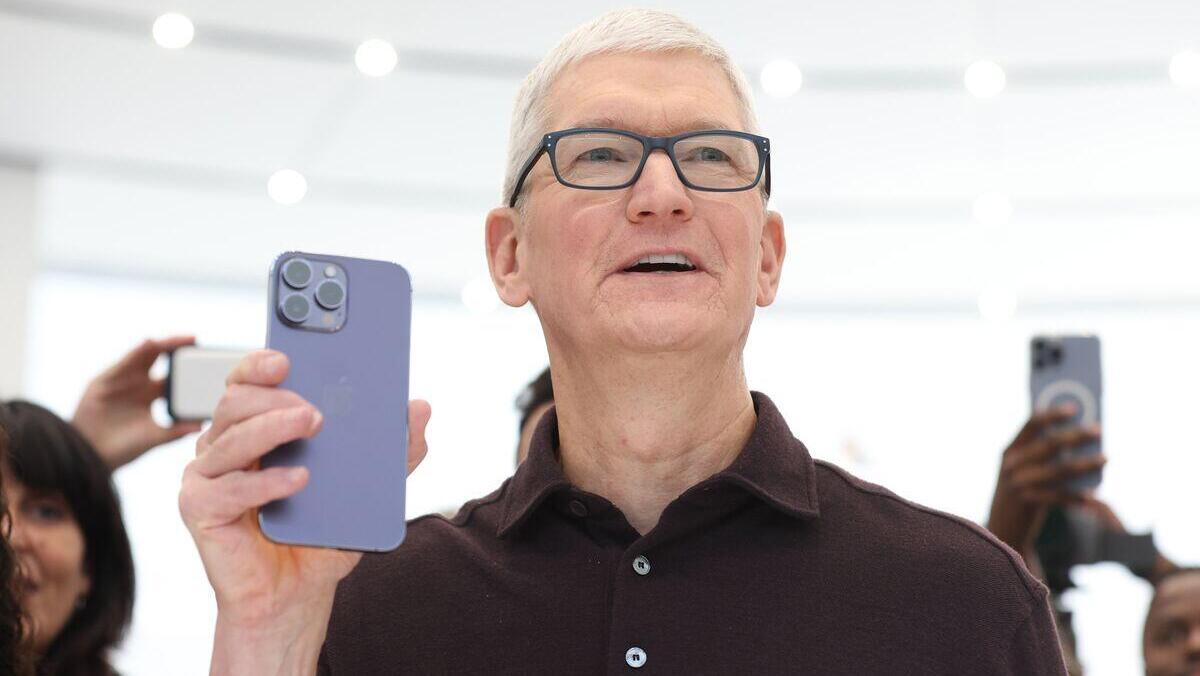 טים קוק מנכ"ל אפל מחזיק אייפון 14