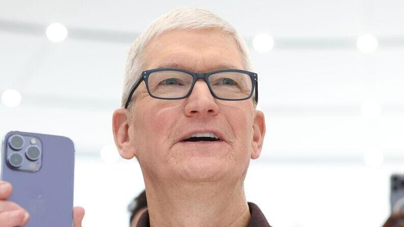 טים קוק מנכ"ל אפל מחזיק אייפון 14