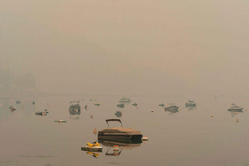 עשן אופף את אגם Shuswap בבריטיש קולומביה, צילום: Paige Taylor White / AFP