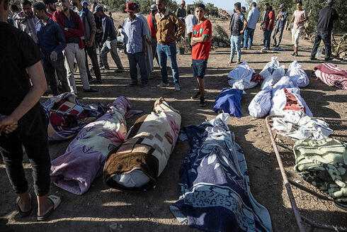 גופות תושבים בכפר Tafeghaghte, צילום: FADEL SENNA / AFP