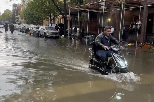 רוכב קטנוע מנסה לצלוח את המים בברוקלין, צילום: AP/Jake Offenhartz