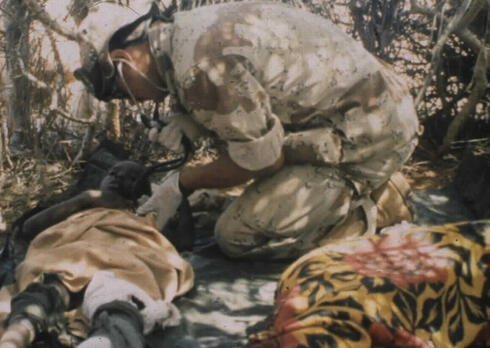 חובש אמריקאי מטפל בילד סומלי פצוע, צילום: US Army