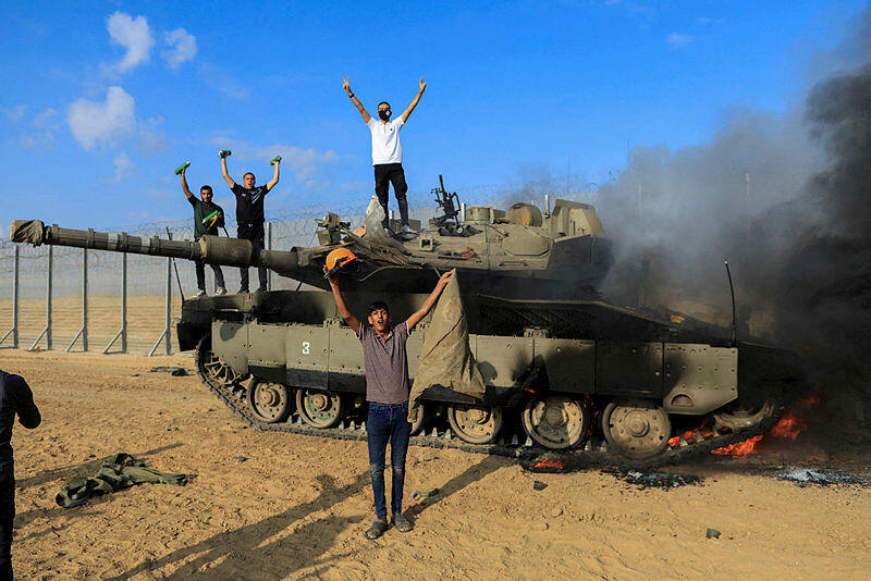 פלסטינים ליד טנק צה"ל שרוף ליד הגבול עם עזה מתקפת פתע מעזה 7.10