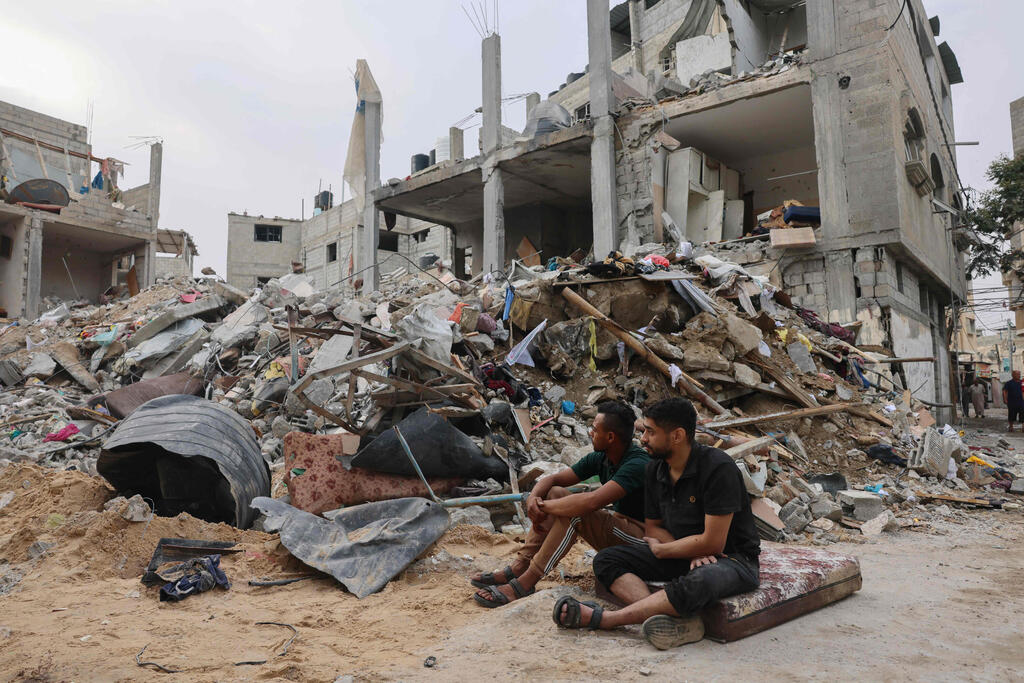 פלסטינים יושבים ליד ההריסות אחרי תקיפות צה"ל 9.10.23