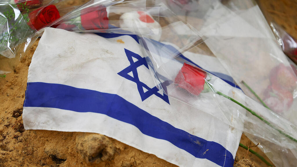 מלחמת עזה דגל ישראל נראה על קבר במהלך הלוויה של רב"ט דביר לישה 15.10.23