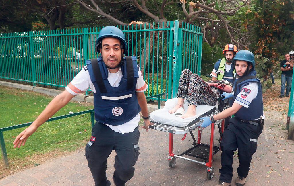 מלחמת עזה חובשים ב אשדוד צוות רפואי מגן דוד אדום מפנים פצועים מ זירת פגיעה של רקטה ב אשדוד
