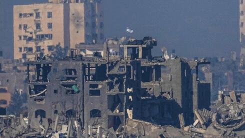 דגל ישראל מתנוסס מעל מבנה הרוס בעזה, צילום: AP