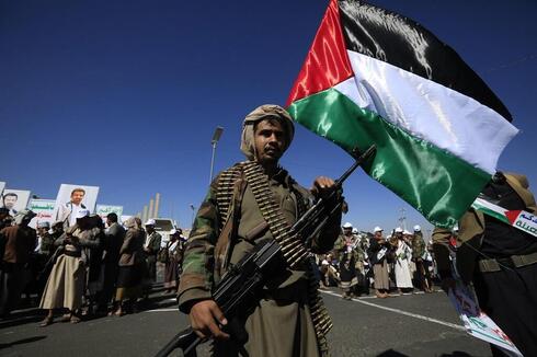Houthi solider holding a Palestinian flag. 