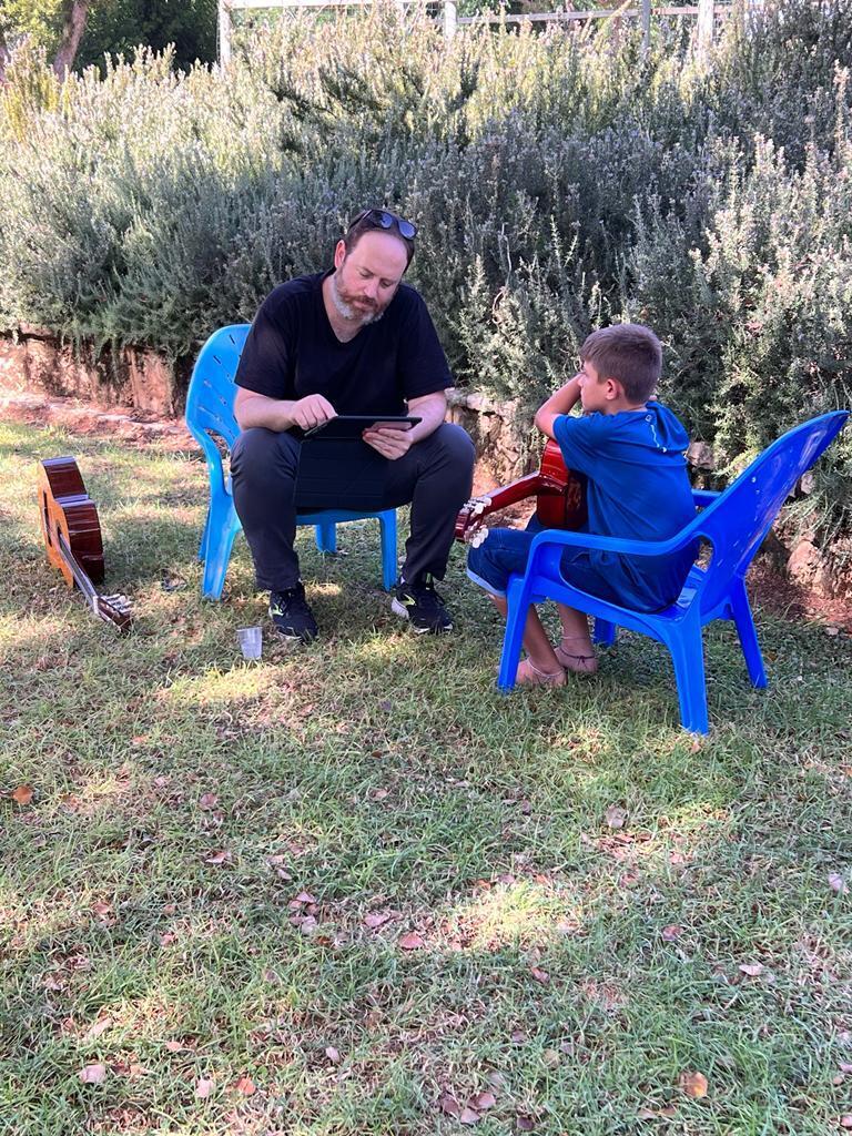 Rani Kliger teaches guitar to the children of Kfar Aza
