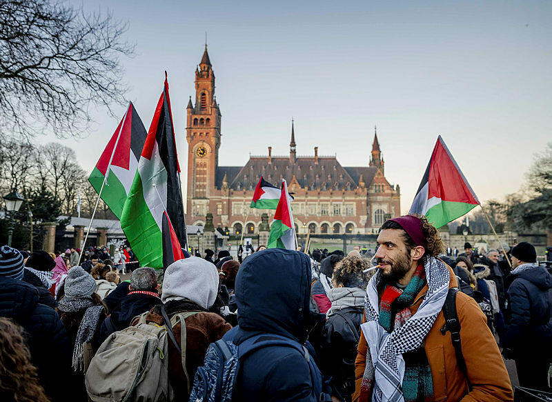 מפגינים פלסטיניים ליד בית הדין הבינלאומי בהאג עם פתיחת המשפט נגד ישראל