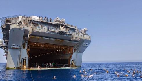 צוות הספינה בטאן מתרווח קצת, וקופץ לשחייה מפתח הפריקה האחורי, צילום: USMC