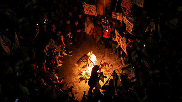 מפגינים מדליקים אש בקפלן, צילום: REUTERS/Hannah McKay