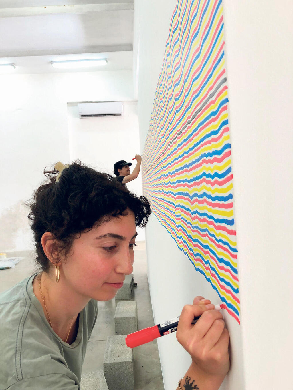 פנאי סטודנטים מבצעים ציור קיר של לוויט לתערוכה עם נחום טבת