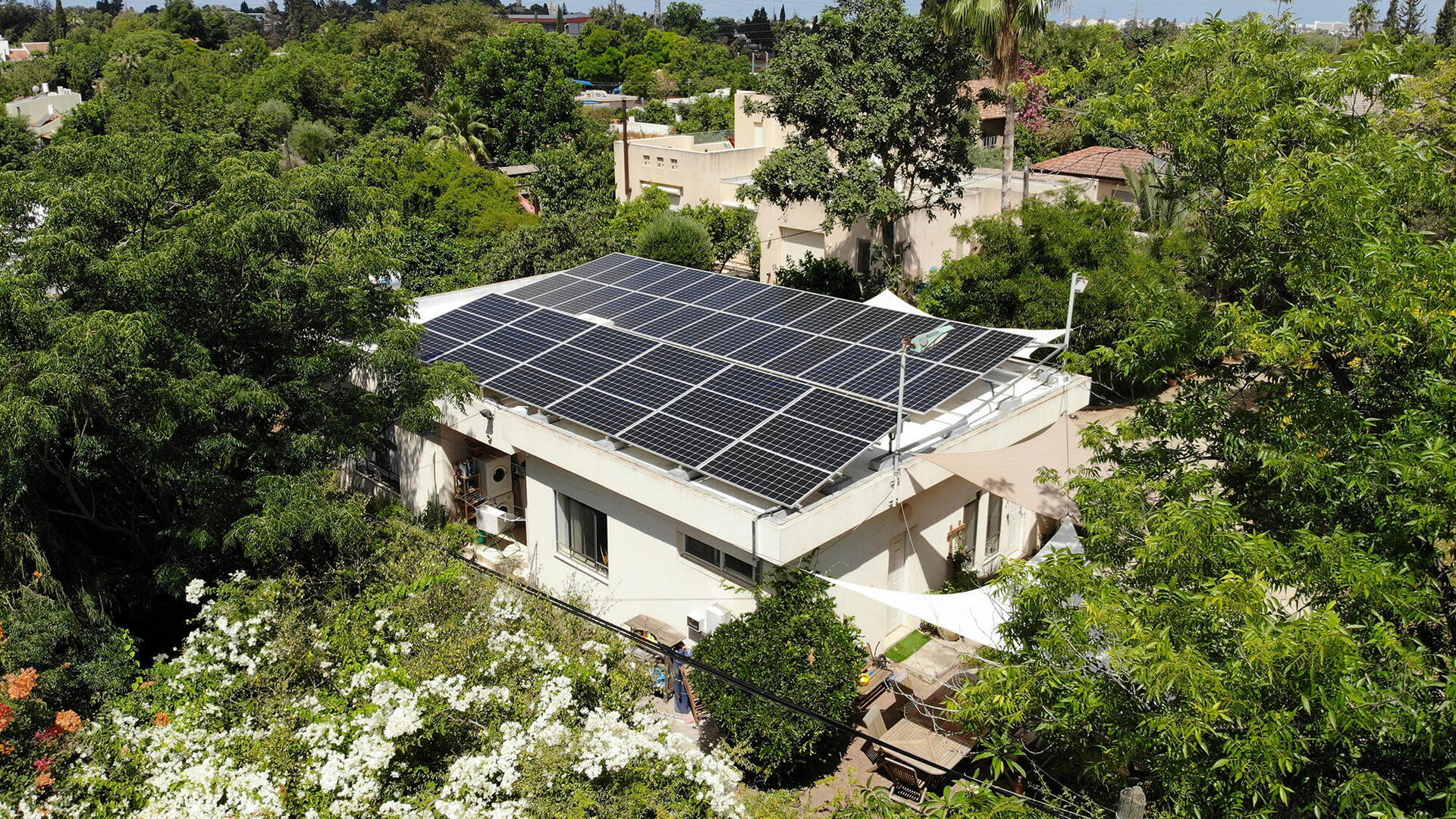 גג בבית פרטי מכוסה פאנלים סולאריים ל ייצור אנרגיה ירוקה