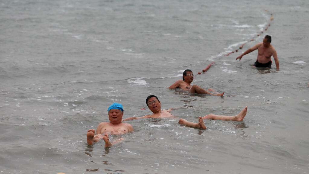 תיירים מבלים בים המלח (ארכיון מימים רגועים יותר) (צילום: עמית שאבי) תיירים מ סין מבלים ב ים המלח ב חוף קליה