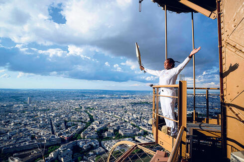 Hoisting the Olympic torch atop the Eiffel Tower 