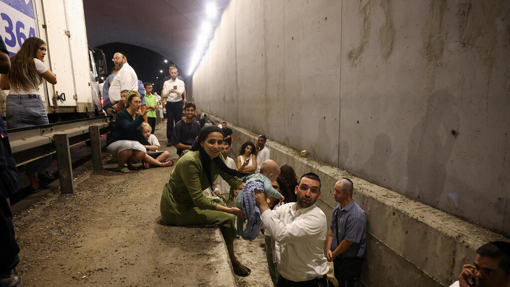 אנשים באיזור מוגן לצד הכביש במרכז הארץ בעקבות יירוט יירוטים ירי טילים תקיפה מ איראן