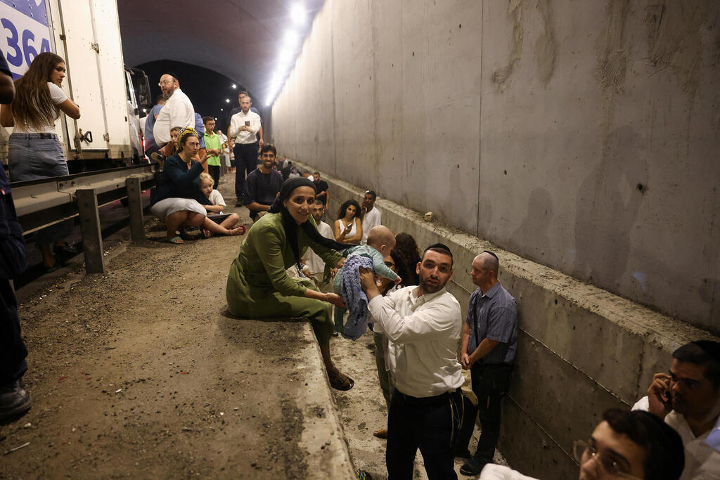 אנשים באיזור מוגן לצד הכביש במרכז הארץ בעקבות יירוט יירוטים ירי טילים תקיפה מ איראן