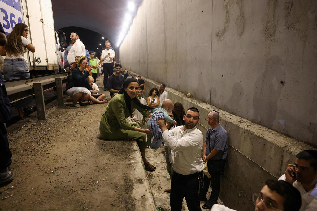 אנשים באיזור מוגן לצד הכביש במרכז הארץ בעקבות יירוט יירוטים ירי טילים תקיפה מ איראן