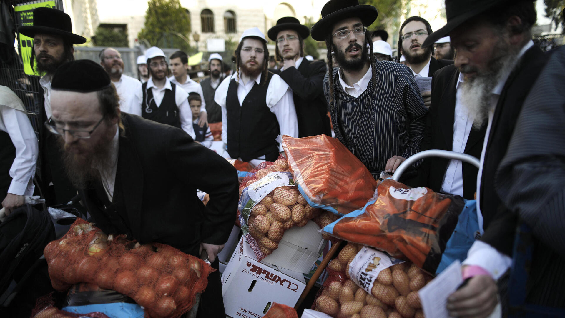 חלוקת מזון לפני פסח בשכונת מאה שערים. כלכלה מבוססת גמ"חים ומקורות סיוע אחרים