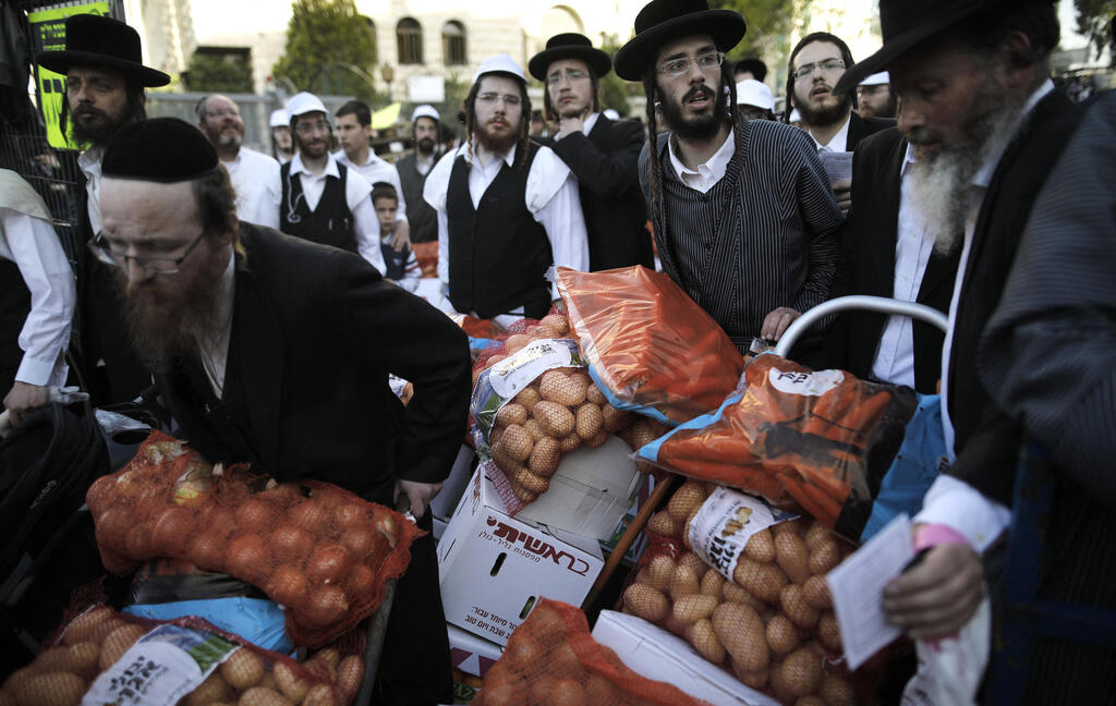 חלוקת מזון לפני פסח בשכונת מאה שערים. כלכלה מבוססת גמ"חים ומקורות סיוע אחרים