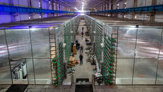 דאטה סנטר עתיר ביצועים מהנדסים ממיינים ומתקינים אסדות כרייה בחוות כריית המטבעות הקריפטוגרפיים CryptoUniverse ב-Nadvoitsy רוסיה