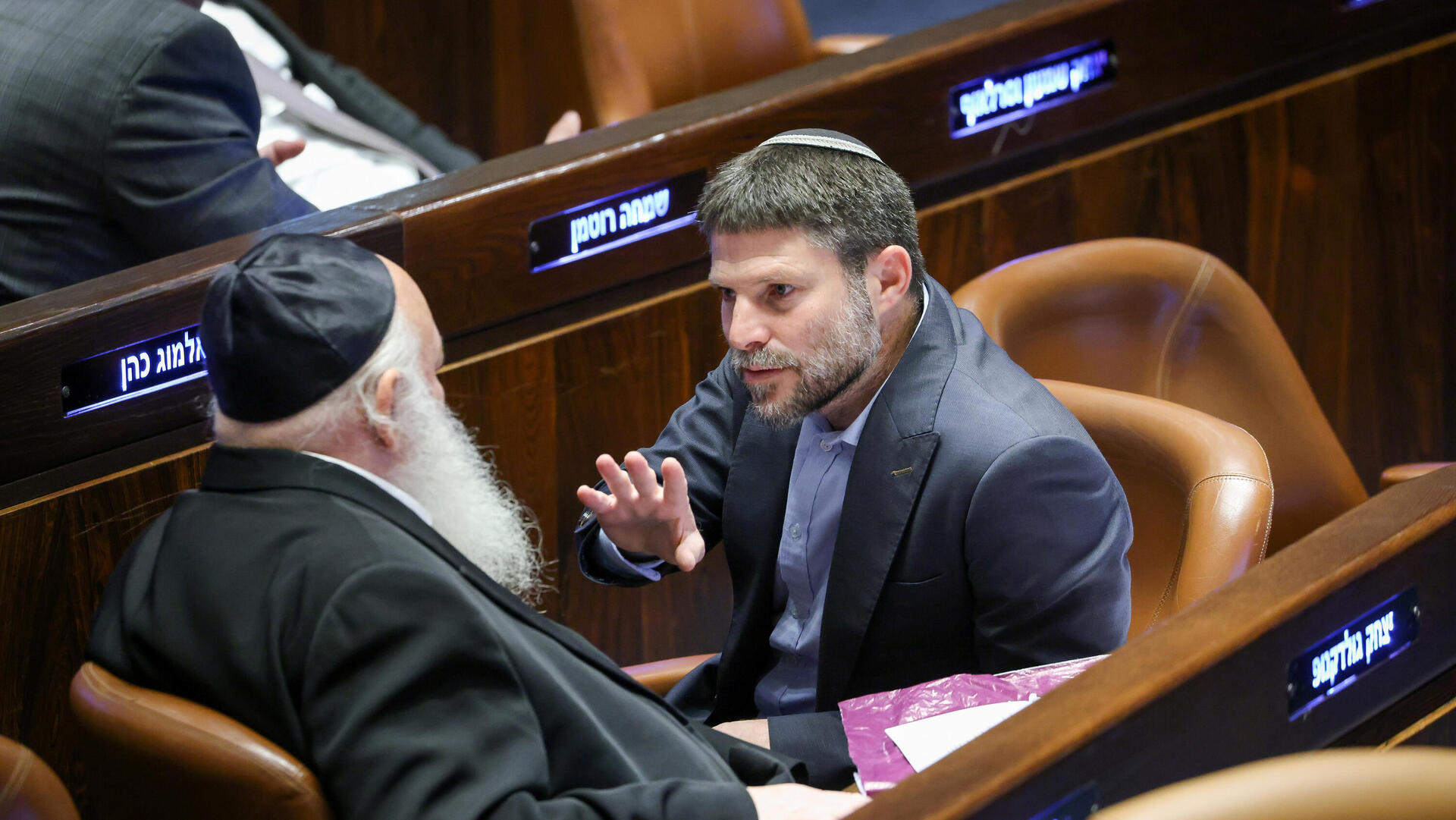 דוד בן־גוריון והרב יהודה לייב פישמן מימון חותמים על מגילת העצמאות, מאי 1948 ; בצלאל סמוטריץ' ויצחק גולדקנופף בכנסת, דצמבר 2022 . "הקנאים לא ציונים ולא מתביישים בזה. סמוטריץ' היה חותם על מגילת העצמאות?"