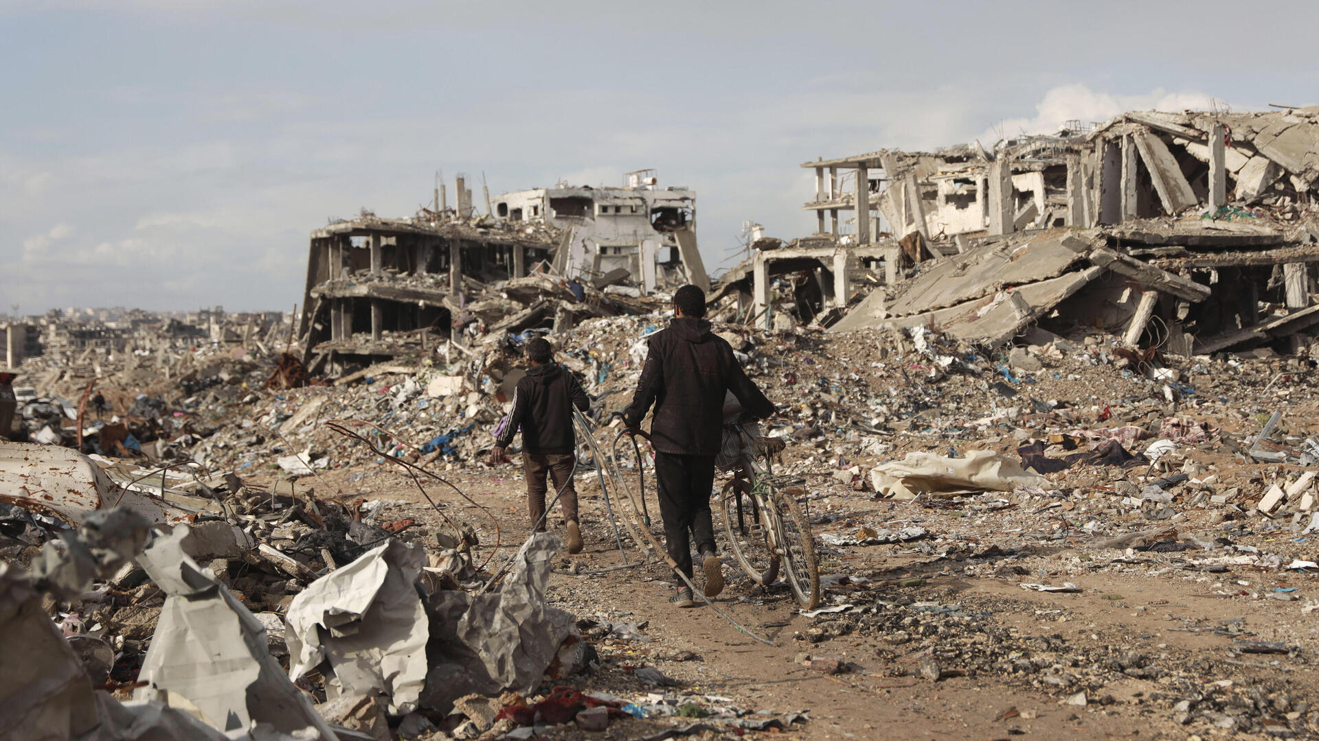 פלסטינים הולכים בין ה הריסות ב רצועת עזה 24.1.25