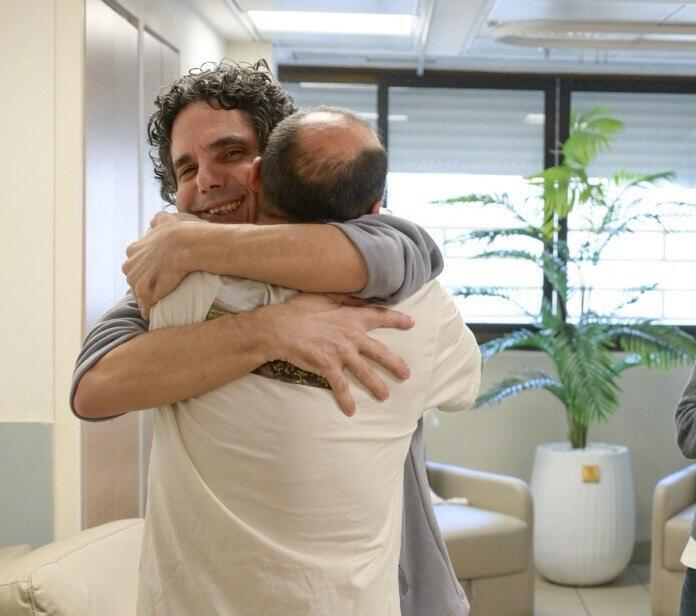 ניסן קלדרון (עם הגב למצלמה) מחבק את אחיו עופר שחזר מהשבי (צילום: דובר צה"ל) ניסן קלדרון מחבק את אחיו עופר קלדרון שחזר מהשבי