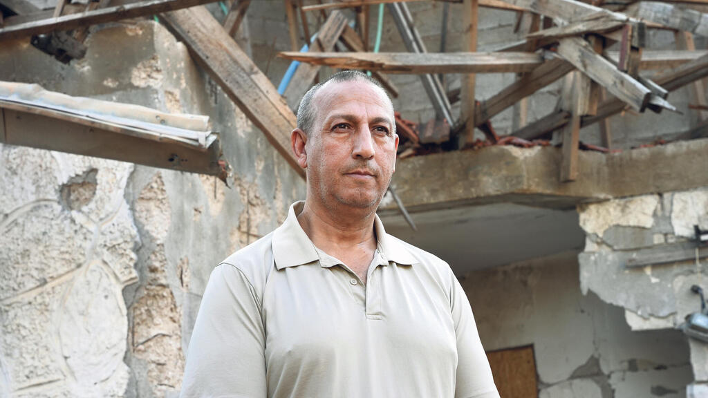 דוד אזולאי (צילום: אפי שריר) ראש המועצה המקומית מטולה דוד אזולאי על רקע בית הרוס