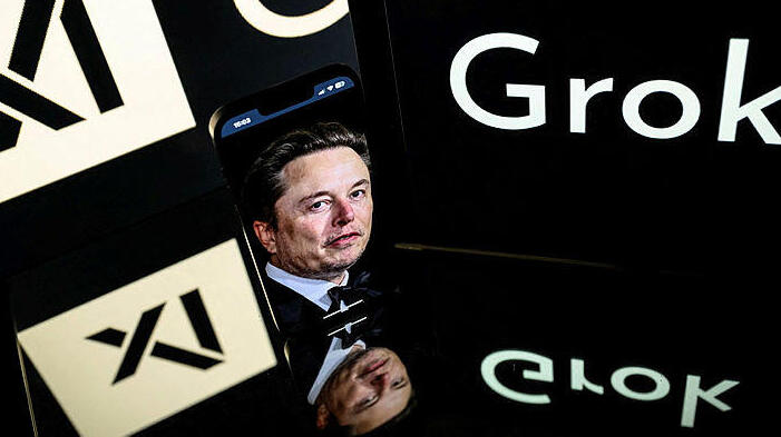 אלון מאסק גרוק xAI בינה מלאכותית צילום של מסכים בתערוכה טכנולוגית