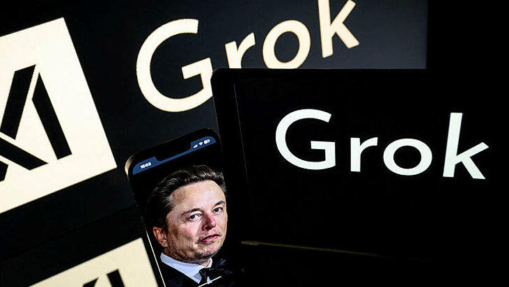 אלון מאסק גרוק xAI בינה מלאכותית צילום של מסכים בתערוכה טכנולוגית