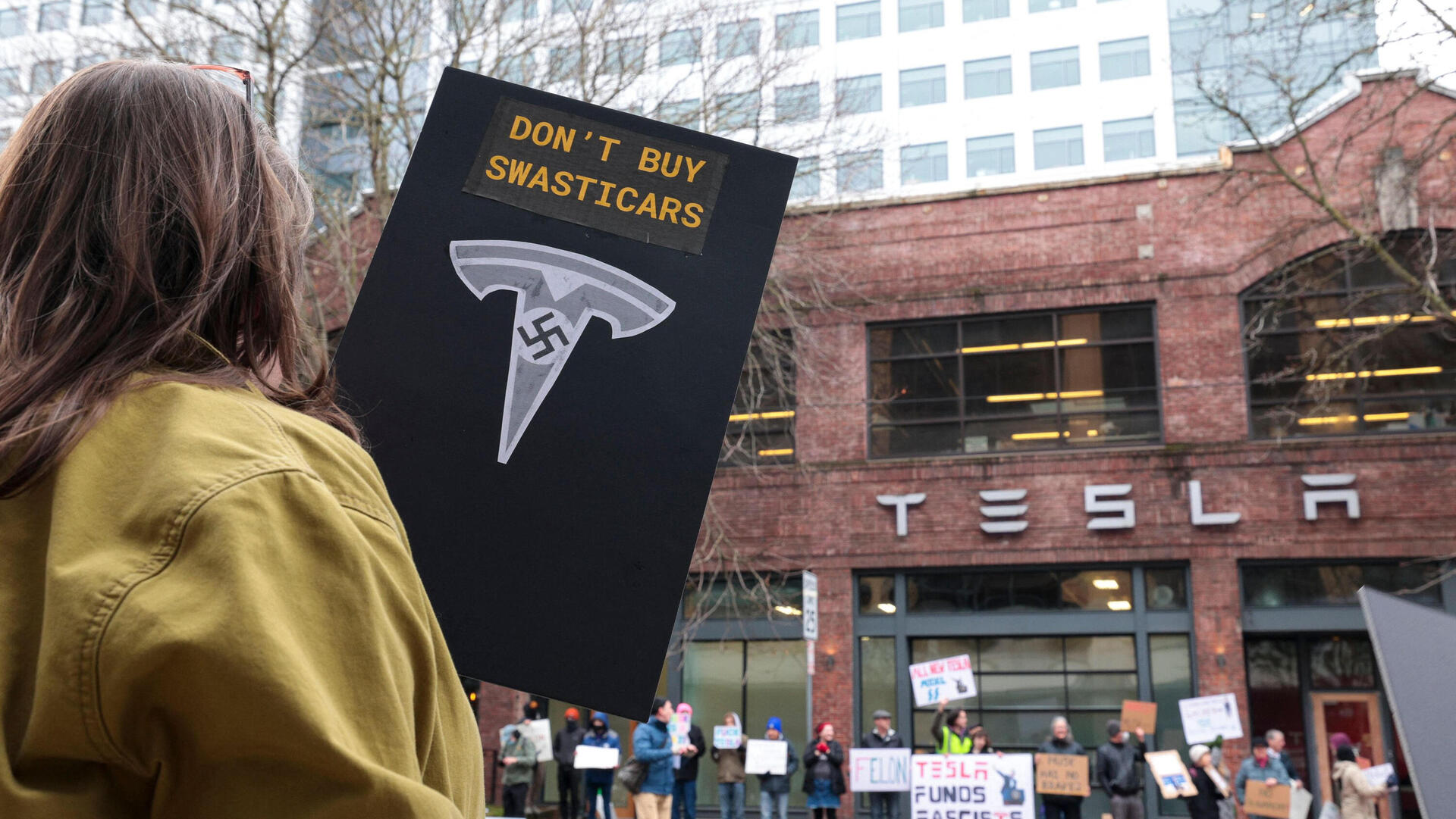 מחאה נגד אלון מאסק מול אולם תצוגה של טסלה ב סיאטל 15.2.25