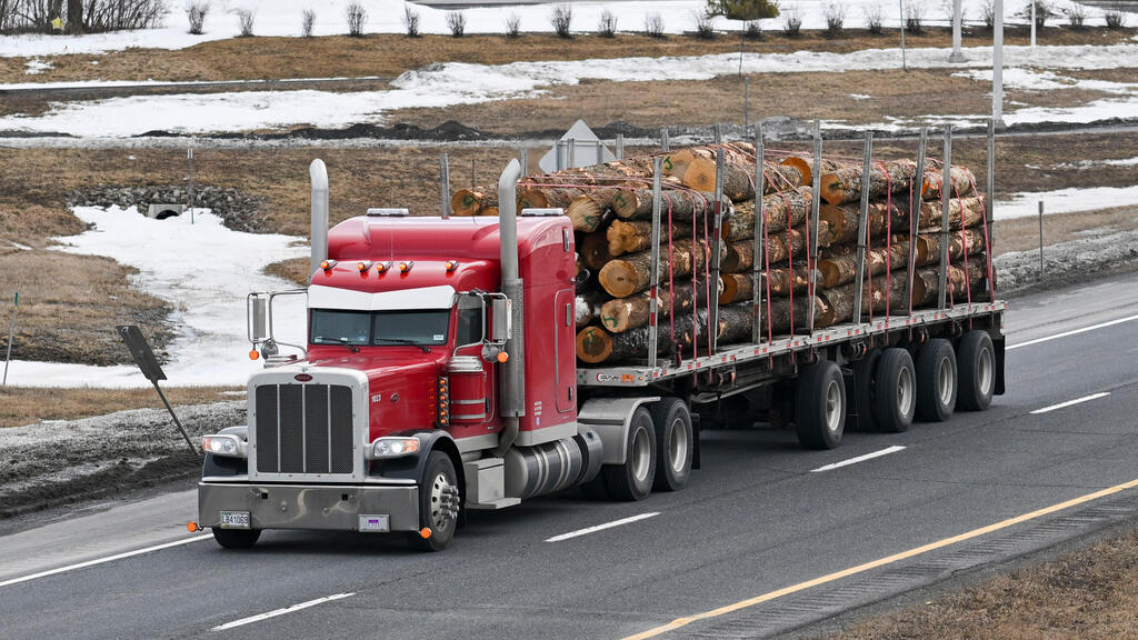 משאית עם בולי עץ עצים ב קנדה עושה את דרכה לגבול עם ארה"ב מלחמת סחר מכסים
