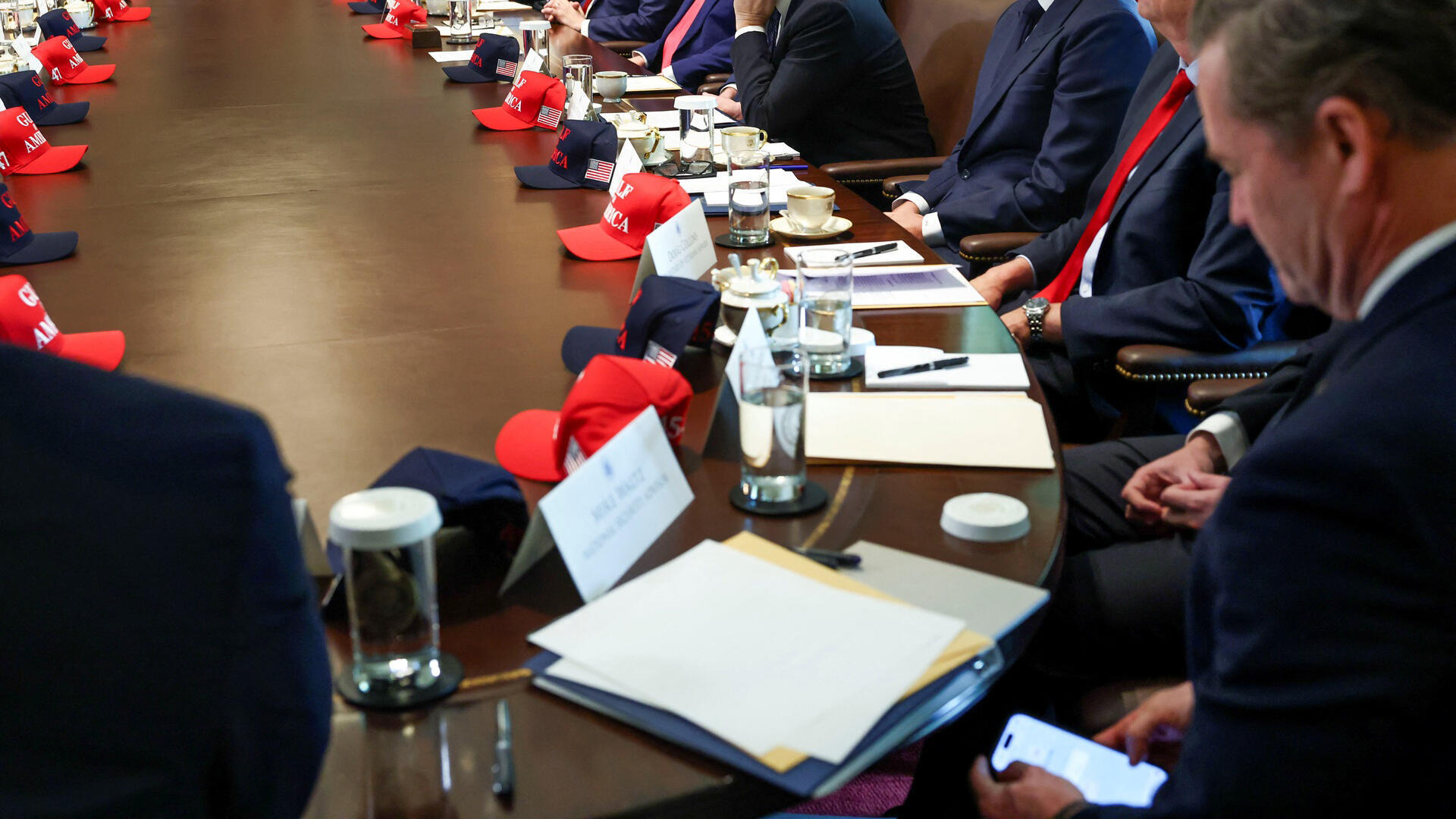 מייק וולץ היועץ היוצא לביטחון לאומי תועד גולש באמצעות טלמסג' במהלך ישיבת קבינט לצד הנשיא טראמפ ב 30 באפריל 2025