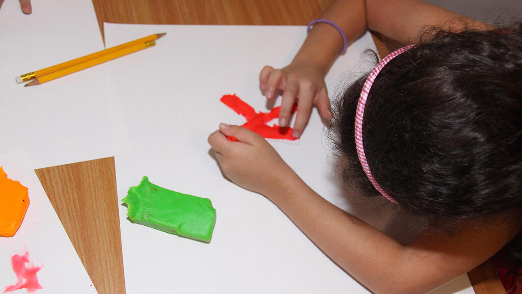 ילדה מדביקה אותיות ב חוג ל הכנה ל כיתה א ב סטודיו במגע ב מודיעין 