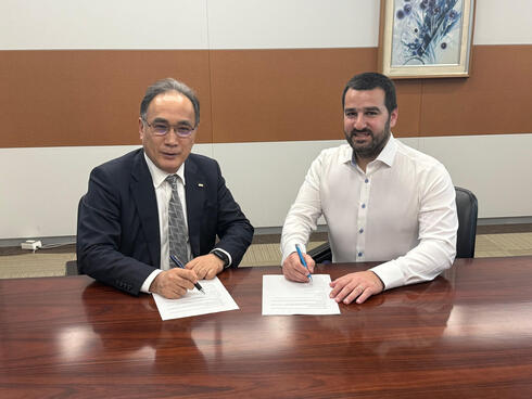 Kazuyuki Yoshimura of KDDI (left) and Ido Susan of DriveNets sign a strategic partnership agreement. 