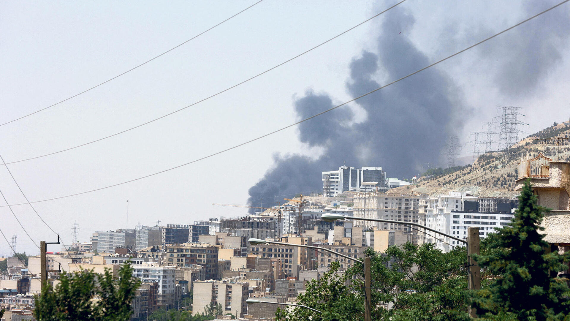 עשן מיתמר בעקבות מה שאיראן טוענת כתקיפה ישראלית על מתקן נפט ליד טהראן