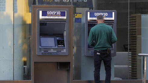צילום: Kobi Wolf/Bloomberg הריבית יורדת, אבל הבנקים ממשיכים לגזור את הקופון